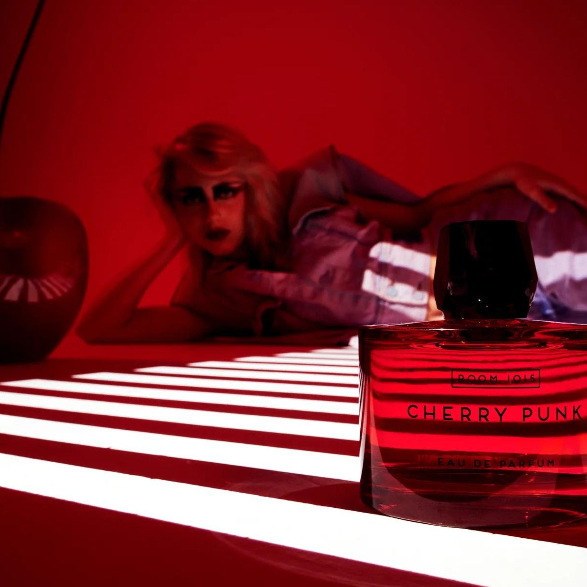 Image showcasing Cherry Punk, Room 1015's bestselling fragrance, depicted as a vibrant perfume bottle with rebellious cherry-red accents, embodying the wild spirit of punk rock.