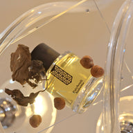 An up-close look at the chic 'Hazelnut Patchouli' perfume bottle, a testament to Les Indemodables' commitment to creating high-quality, unique fragrances.